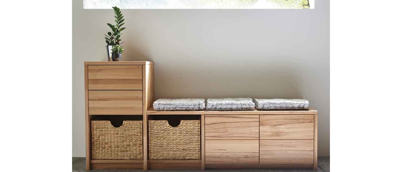 Gemütliches Wohnzimmer mit grauem Sofa, geflochtenen Dekoartikeln und Holzmöbeln. Ein runder Einsatz zeigt eine Lagerregalillustration mit Haken und Fächern auf grünem Hintergrund. Neutrale Farbpalette und Parkettboden.