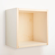 Ein buchenblauer Regalwürfel farbig 36 x 36 cm, mit einem minimalistischen offenen Würfeldesign mit klaren Linien und einem hellen Holzfinish, wird an einer schlichten weißen Wand montiert und sorgt für einen einfachen, modernen Look.