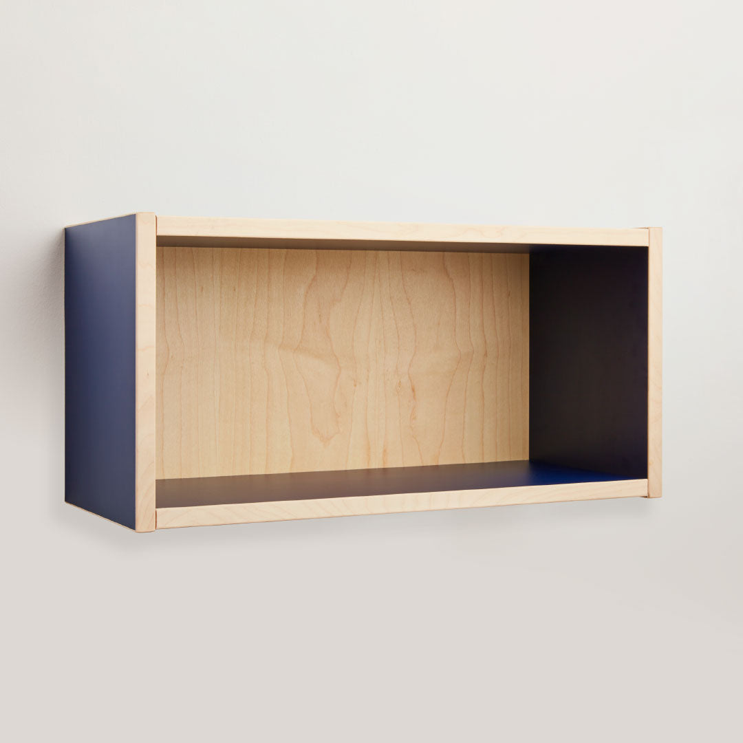 Der buchenblau Regalwürfel farbig besticht durch sein helles Holzdekor mit blauen Seitenteilen und wird an einer hellen Wand montiert. Das 60 x 30 cm große Regal bietet eine offene Front ohne Fächer und eignet sich ideal zur Präsentation von Dekorationen.