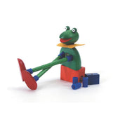 Die buchenblaue Frosch Quak - Kellner Steckfigur hat lange grüne Beine, blaue Gelenke, rote Schuhe und einen gelben Kragen. Sie sitzt auf einem roten und blauen Block mit losen blauen Teilen und einem kleinen blauen Block in der Nähe.