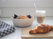 Frühstückstisch mit Kaffeetasse und Croissant