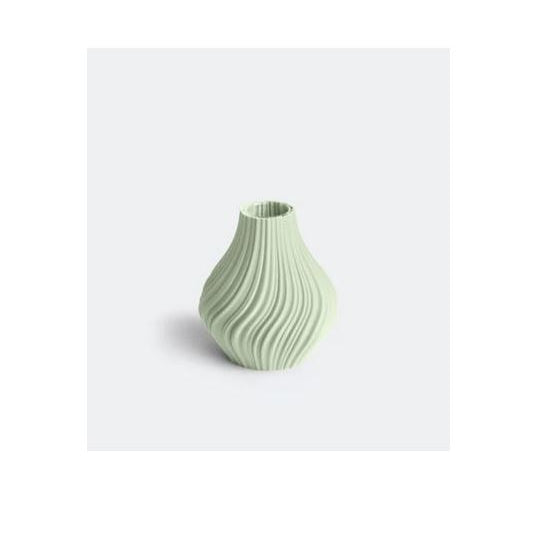 Die Vase „Swirl“ S in Salbei von nevalu in einem hellen Grünton mit strukturiertem Wellenmuster aus recyceltem Kunststoff präsentiert sich auf einem schlichten hellgrauen Hintergrund.