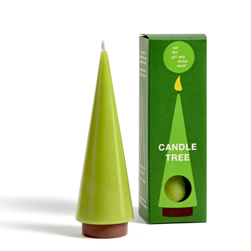 Eine grüne, baumförmige Kerze aus Stearin-Wachs steht neben der dazu passenden minimalistischen Verpackung. Die Schachtel zeigt das gleiche Baumdesign mit „Candle Tree M moos“ und einer Sprechblase mit der Aufschrift „nicht das Mädchen, das viel vermisst“. Perfekt, um Wärme und Stil zu verleihen.