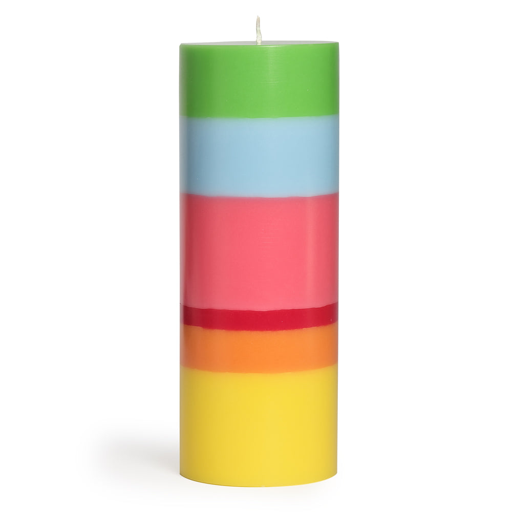 Die Große Kerze Zuversicht von not the girl ist eine zylindrische Stearin-Kerze mit weißen Docht und bunten, horizontalen Streifen in Grün, Hellblau, Pink, Rot, Orange und Gelb. Fair gehandelt und aufrecht vor weißem Hintergrund.