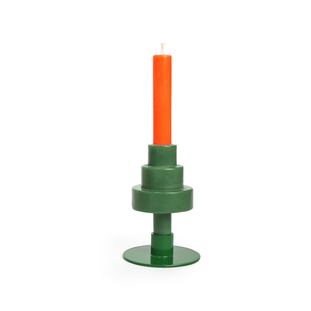 Der "Party Candle Xmas Tree" von not the girl ist ein grüner, gestufter, geometrischer Kerzenhalter mit einem flachen Sockel, der eine hohe orangefarbene Stearin-Wachs-Kerze vor einem schlichten weißen Hintergrund hält.