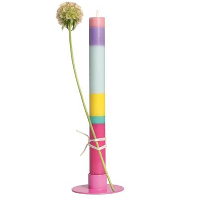 Eine bunt gestreifte Grußkerze - Geburtstag von not the girl, in einem rosa Halter, geschmückt mit einer einblütigen Blume. Die runde, zartgelbe Blüte verstärkt die entspannende Aura der Kerze und ist paraffinfrei aus Stearin-Wachs.