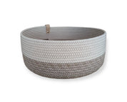 Der Koba Korb „Koba Bowl Boho Mele & White“ ist ein runder Aufbewahrungskorb aus recycelter Baumwolle mit weiß-beigem Zickzackmuster und heller Lederschlaufe, handgefertigt von der Marke Koba.