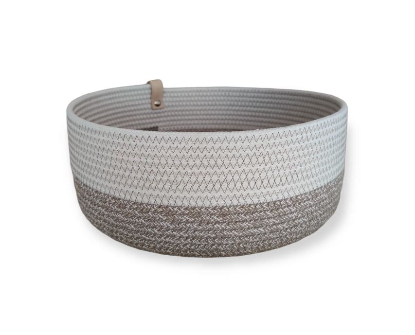 Der Koba Korb „Koba Bowl Boho Mele & White“ ist ein runder Aufbewahrungskorb aus recycelter Baumwolle mit weiß-beigem Zickzackmuster und heller Lederschlaufe, handgefertigt von der Marke Koba.
