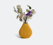 Die Vase „Raindrop“ in Ocker von nevalu, ein leuchtend gelbes geripptes Keramikstück, enthält ein atemberaubendes Arrangement aus getrockneten Blumen, darunter hellgrüne Eukalyptusblätter, zartes weißes Schleierkraut und einige violette Strandfliederblüten. Die Vase steht vor einem schlichten weißen Hintergrund.